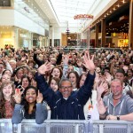 Pictured above is an excited crowd of people waving and smiling to camera.