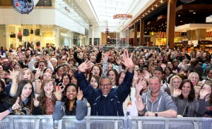 Pictured above is an excited crowd of people waving and smiling to camera.