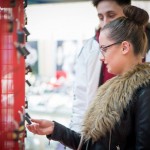 Woman looking at padlocks attached to giant Valentine heart installation at Love Lock-In retail event, Cardiff