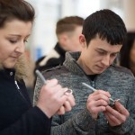 Couple writing Valentine messages on padlocks at Love Lock-In retail event, Cardiff